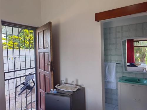 a bathroom with a sink and a door with a window at MayBach Hills Palace Guesthouse in Saldanha