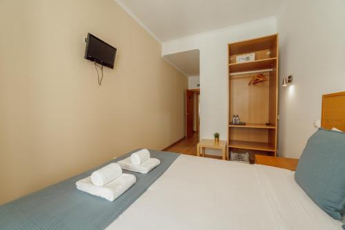 a bedroom with a bed with two towels at Rossio Suites By Hosty in Lisbon