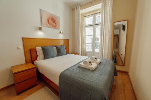 a bedroom with a bed with two towels on it at Rossio Suites By Hosty in Lisbon