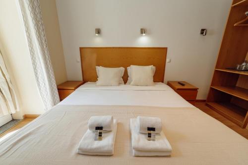 a bedroom with a bed with two towels on it at Rossio Suites By Hosty in Lisbon