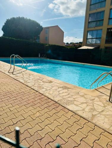 une grande piscine bleue devant un immeuble dans l'établissement Le Lavandin, à Sanary-sur-Mer