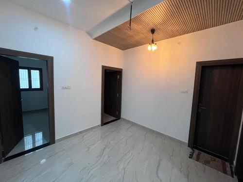 an empty room with two doors and white walls at Hridayam Kashi Homestay in Varanasi