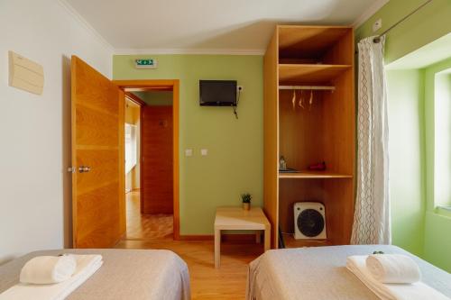 a room with two beds and a tv on the wall at Rossio Suites By Hosty in Lisbon