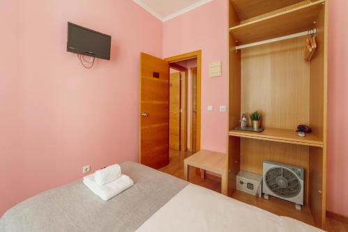 a bedroom with a bed and a tv on the wall at Rossio Suites By Hosty in Lisbon