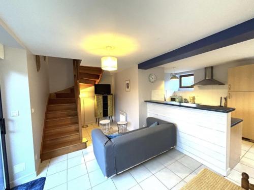 un salon avec un canapé et une cuisine dans l'établissement Gite Abéria petite maison coquette, à Saint-Alban