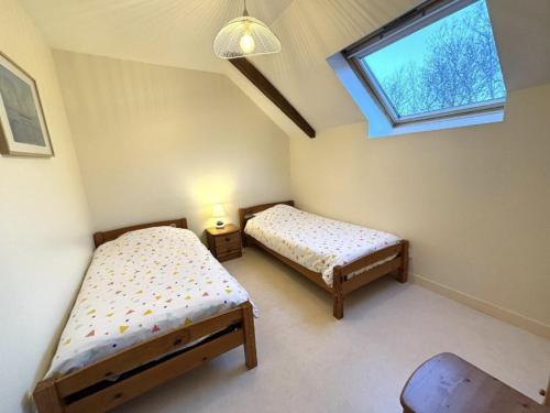 une chambre avec deux lits et une fenêtre dans l'établissement Gite Abéria petite maison coquette, à Saint-Alban