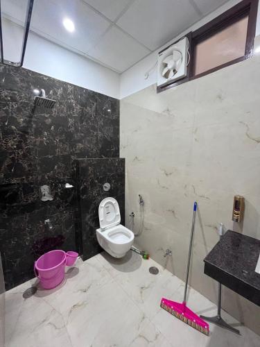 a bathroom with a white toilet and a black wall at Hridayam Kashi Homestay in Varanasi