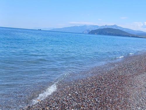 a beach with blue water and mountains in the background at Studio 2 in Ayia anna