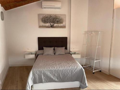a bedroom with a bed and a tree on the wall at Apartamento Isabel in Ardales