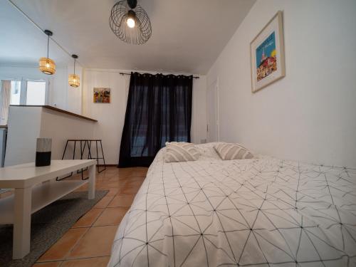 une chambre avec un lit blanc et une table dans l'établissement Appartement climatisé avec parking 4 couchages à 5min à pieds de la gare ST Charles, à Marseille