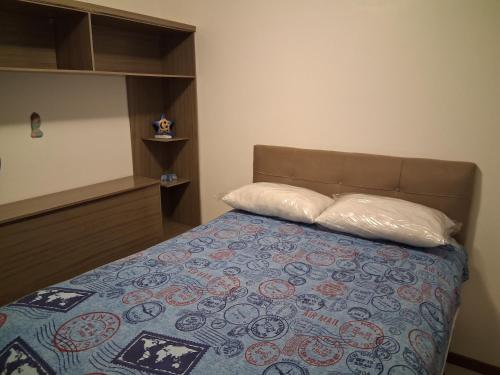 un dormitorio con una cama con dos almohadas. en Apartamento em Meia Praia, Itapema, SC., en Itapema
