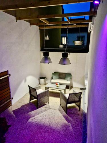 - un salon avec un éclairage violet et un canapé dans l'établissement Studio Chic avec Terrasse Privée et Vue Falaise, à Quimper