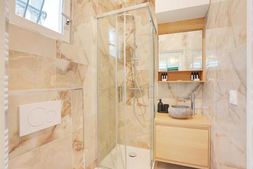 une douche avec une porte vitrée dans une salle de bain dans l'établissement Chic and Cosy Apartment-Canal Saint Martin, à Paris