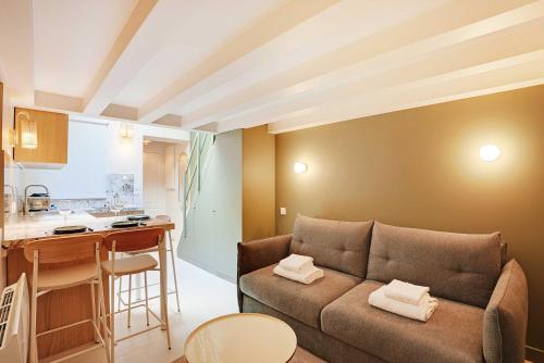 un salon avec un canapé et une cuisine dans l'établissement Chic and Cosy Apartment-Canal Saint Martin, à Paris