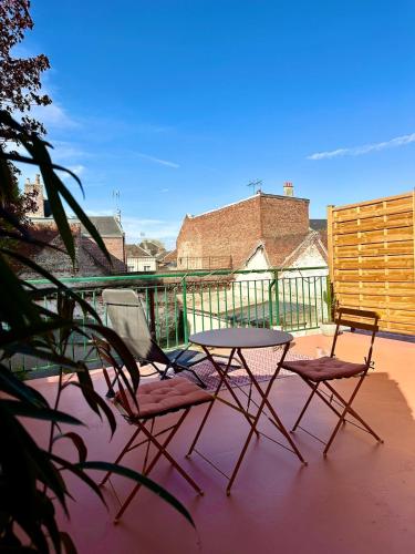 two chairs and a table on a patio at "Nuits du désert" - Appartement avec terrasse in Saint-Quentin
