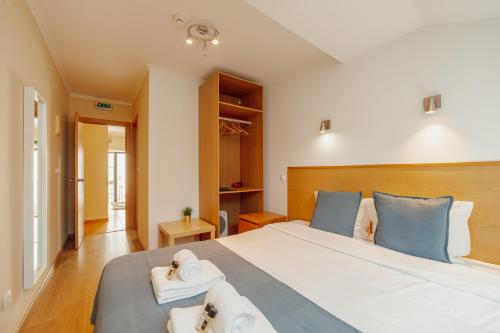 a bedroom with a large bed with towels on it at Rossio Suites By Hosty in Lisbon