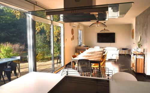 a kitchen and dining room with a table and chairs at Villa Spacieuse au Calme Absolu avec Grande Piscine Jacuzzi Chauffé - Grand Jardin Sans Vis a vis- Salle de Jeux avec Fresque du Nougat - Ideal Familles et Groupes Drome Provencale in Montélimar
