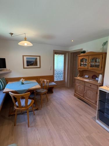 a living room with a table and chairs and a kitchen at Ferienhaus Christern in Grundlsee