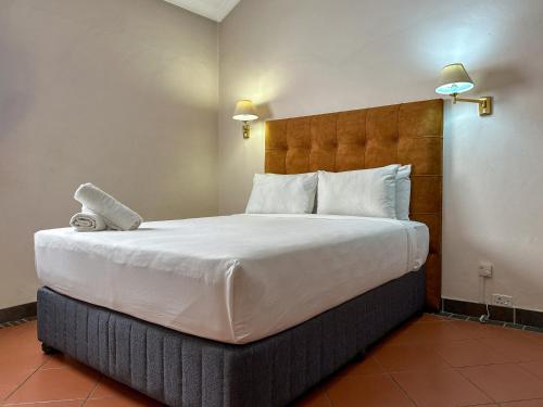 a bedroom with a large bed with white sheets and pillows at Park Gables Loftus Guest House in Pretoria