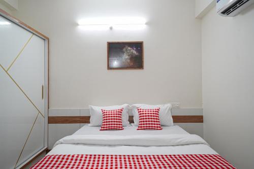 une chambre avec un lit avec des oreillers rouges et blancs dans l'établissement Open Hotel by Olive - Buzz Studio, à Lingampalli