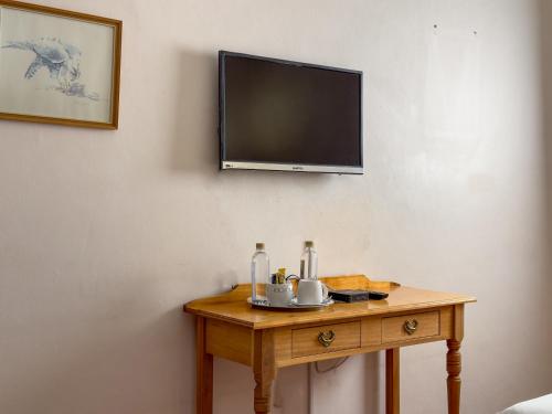 a wooden table with a television on a wall at Park Gables Loftus Guest House in Pretoria