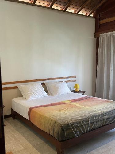 a bedroom with a bed in a room with a wall at App Lory KiteVillage in Uruau