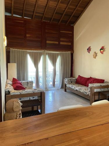 a living room with two beds and a large window at App Lory KiteVillage in Uruau
