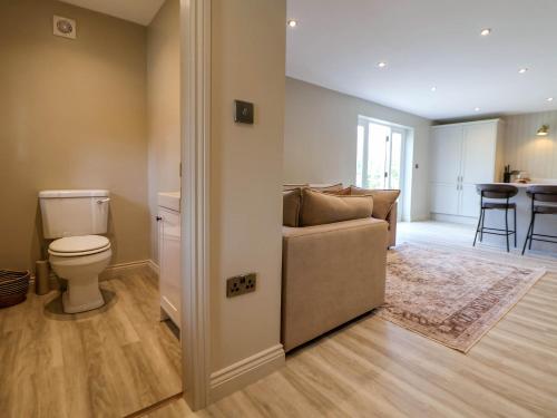 a living room with a toilet and a couch at Egerton Cottage in Crewe