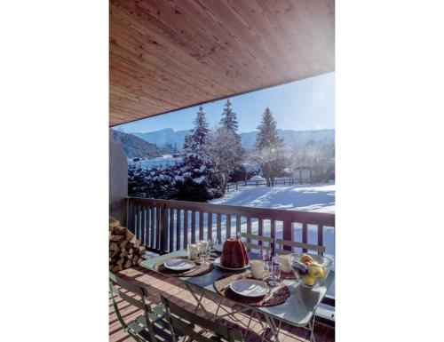 a table on a balcony with a view at Modern 2 bedroom apartment, close to ski lifts in Megève