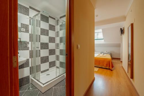 a bathroom with a shower and a bed in a room at Rossio Suites By Hosty in Lisbon