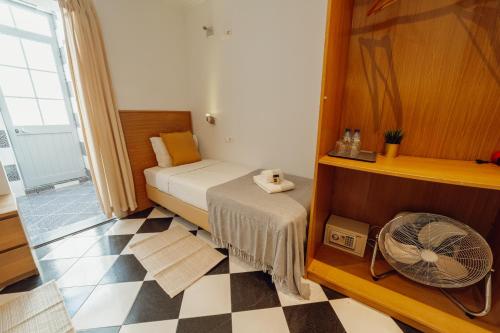 a small room with a bed and a fan at Rossio Suites By Hosty in Lisbon