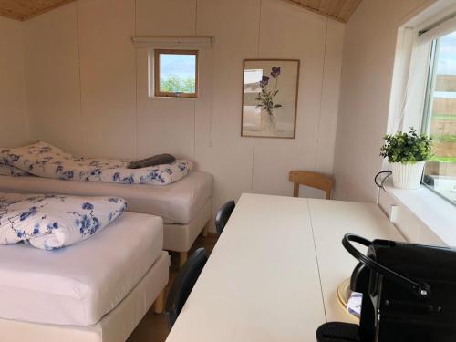 a small room with two beds and a window at Óbót 1 riverside cabin in Egilsstadir