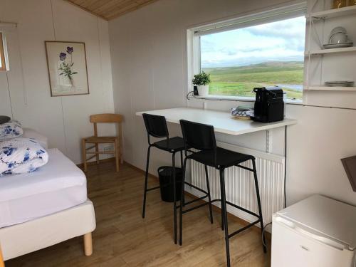 a small room with a table and chairs in a tiny house at Óbót 1 riverside cabin in Egilsstadir