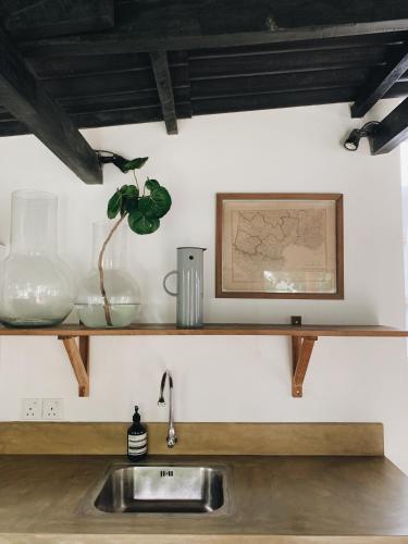a kitchen counter with a sink and a picture on a shelf at Ceylon Sliders in Weligama