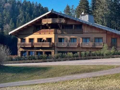 a large wooden building with balconies on the side of it at Domaine de Montagne - Hôtel Chalet Frère Joseph in Ventron