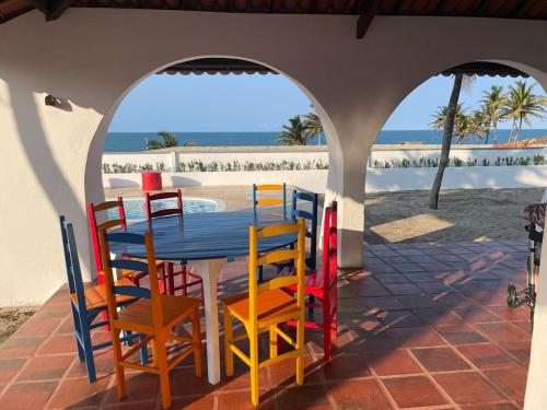 a table and chairs on a patio with the beach at Villa Carlotta Praia Uruaú 5 camere da letto in Beberibe