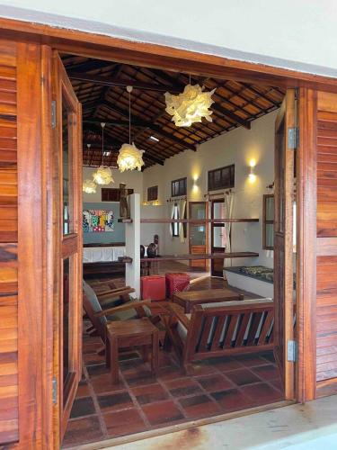a restaurant with wooden tables and chairs in a room at Villa Carlotta Praia Uruaú 5 camere da letto in Beberibe