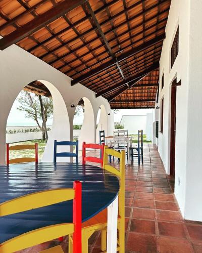 a patio with a table and chairs on it at Villa Carlotta Praia Uruaú 5 camere da letto in Beberibe