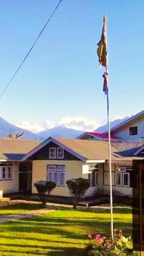 a house with a flag in the front yard at Tripoo Rhisum the premium Haapo retreat in Pelling