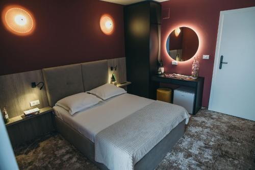 a bedroom with a large bed and a mirror at Grey Residence in Drobeta-Turnu Severin