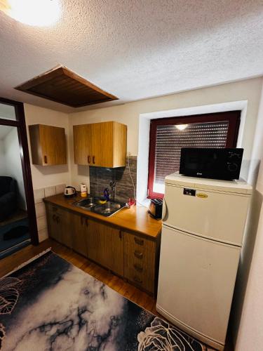 a kitchen with a white refrigerator and a counter at Rooms Cobras II in Jajce