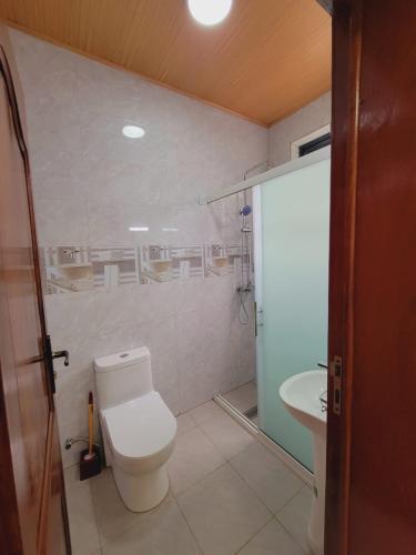a bathroom with a toilet and a sink at Sunset View Hotel and Apartment in Kigali