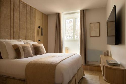 une chambre avec un grand lit et une fenêtre dans l'établissement Cosy apat with AC -3BR- 8P- Canal Saint-Martin, à Paris