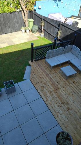 a patio with two chairs and a couch on it at The Oldbrook Garden Flat in Milton Keynes