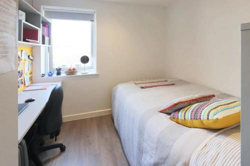 a bedroom with a bed with a desk and a window at Student Only Riverside Way in Winchester in Winchester
