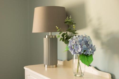 a lamp and a vase of flowers on a table at Loch View House in Loch Gowna in Lough Gowna