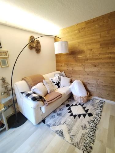 un divano bianco in soggiorno con lampada di A cocoon in Les 2 Alpes a Les Deux Alpes