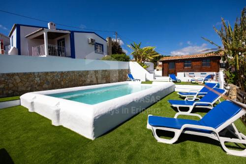 a swimming pool with lawn chairs and a swimming poolvisorvisor at Casa Azul da Relva by AcasaDasCasas in Mafra