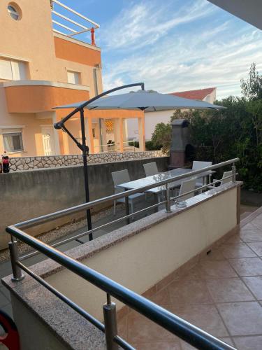 a patio with a table and an umbrella at Apartment IB Studio Pag6 in Kustići