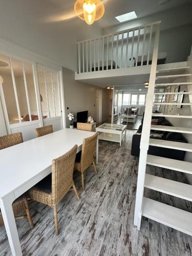 une salle à manger avec une table et des chaises blanches dans l'établissement Salty Home - Appt avec Vue - Wifi Parking, à Les Minimes